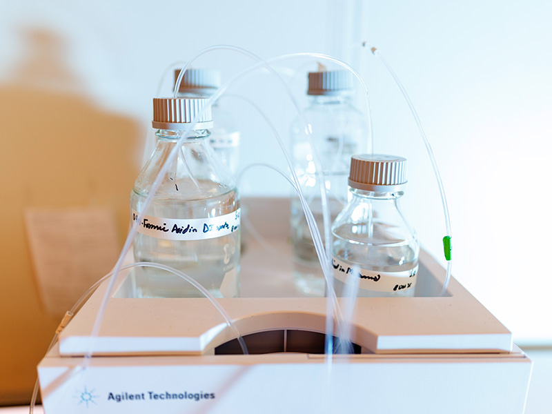 Laboratory bottles connected by tubing are mounted on an analytical instrument.