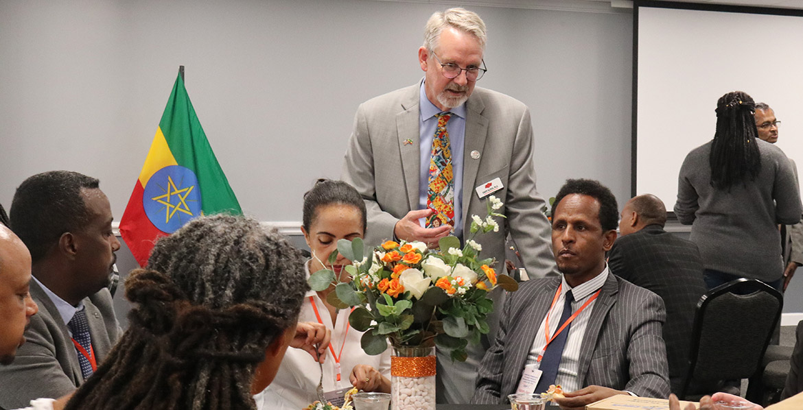 Associate Provost and Dean of OSU Global Dr. Randy Kluver visits with a table of delegates at Ethiopian delegation reception.