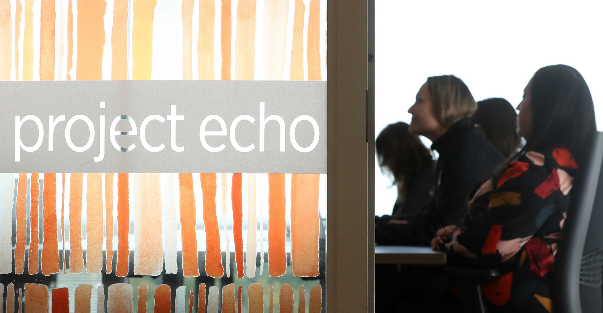 A group of Project ECHO staff and health specialists take part in a virtual ECHO session with rural health providers in one of Project ECHO's teleconference rooms.