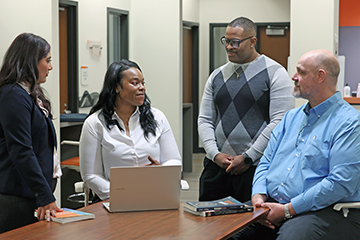 Oklahoma State University Center for Health Sciences Health Care Administration students sit together on campus.