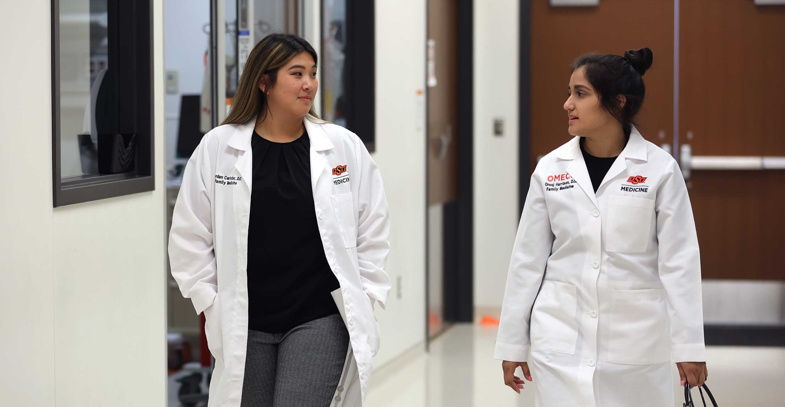 Family medicine residents Dr. Orooj Harrison and Jordan Carinder talk together as they walk down the hall of the hospital Simulation Center on the Oklahoma State University Center for Health Sciences campus in Tulsa.
