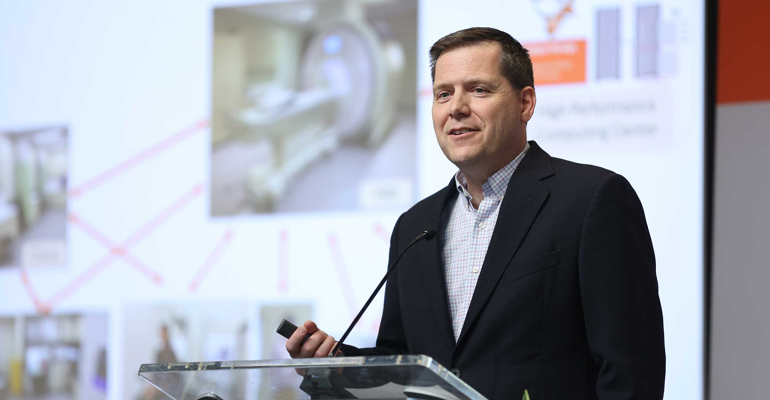 Kyle Simmons, P.h.D., and professor at OSU Center for Health Sciences, speaks at a podium during his presentation at the IGNITE Symposium. 