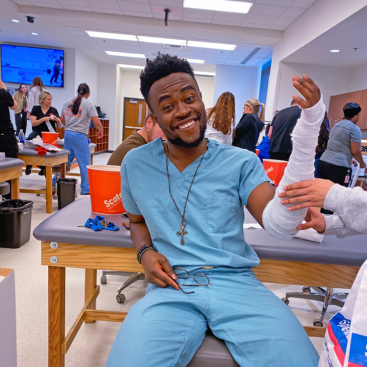 Tomi Adewumi, a fourth year medical student at OSU College of Osteopathic Medicine, volunteers to have his arm cast for a clinical skills lab.
