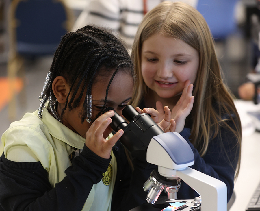 Elementary-age students take part in a microscope lab during a STEM outreach event at the Salvation Army North Mabee Boys & Girls Club hosted by OSU-CHS' Biomedical Sciences Graduate Student Association.