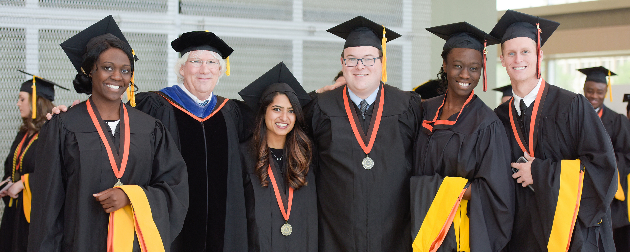 Graduate students stand together following their commencement ceremony in 2018.