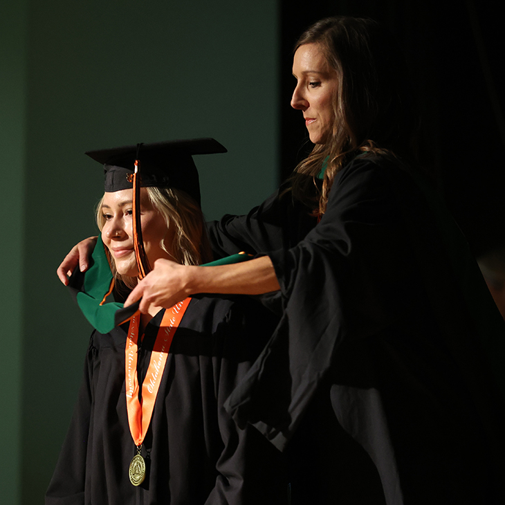 An OSU-CHS Physician Assistant graduate is hooded during the commencement ceremony on Oct. 19, 2023.