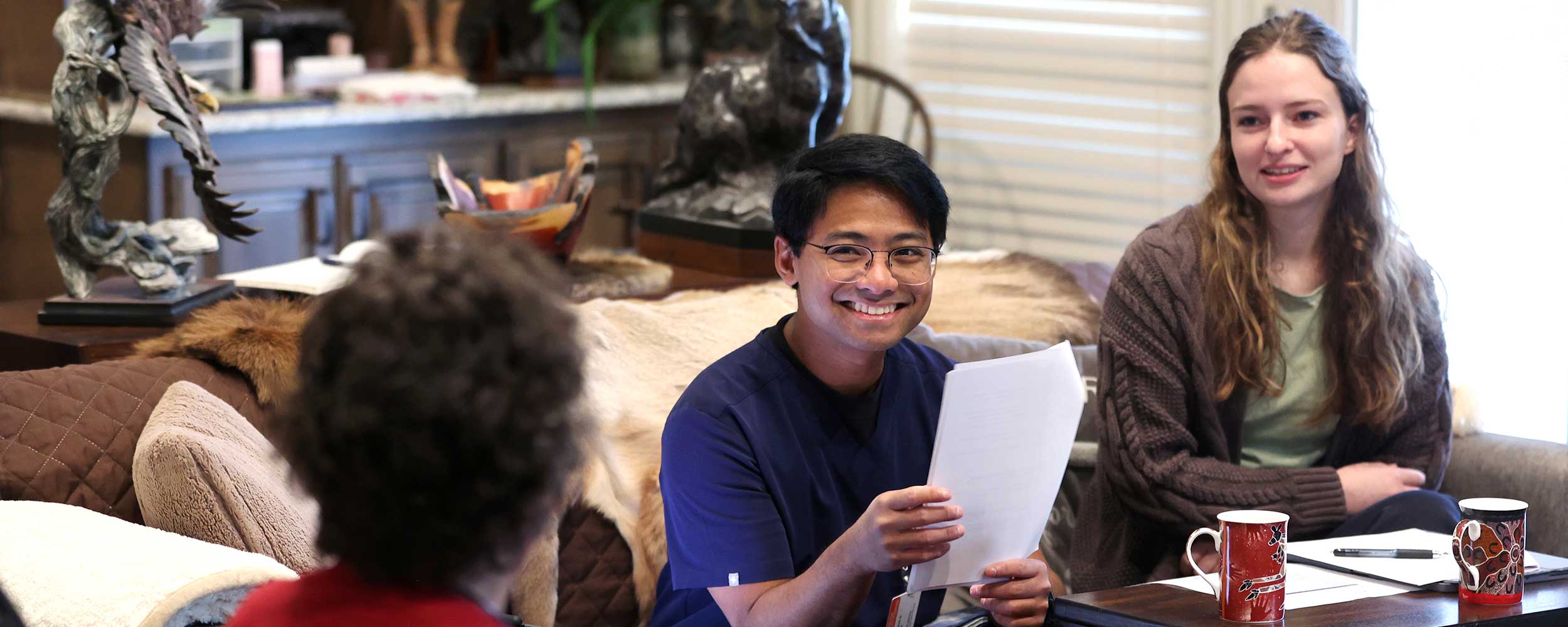 Medical students Kelly Fonk and Audrick Yee meet with senior mentor Mary Elliott at her home.