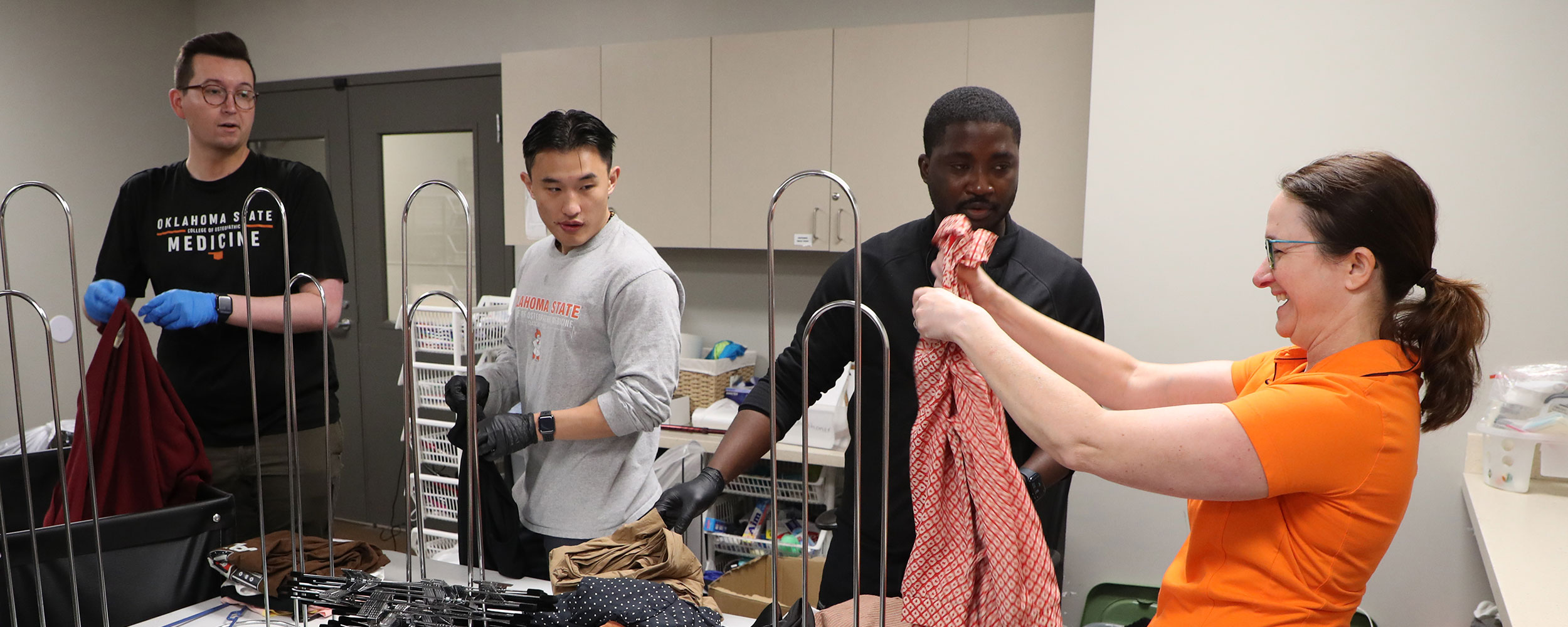 Students from the Urban Underserved Medical Track, including Hayden Jacobs (left), Young Kang and Dennis Ayitiah, volunteer with Dr. Sarah Hall (right) at the Tulsa Day Center.
