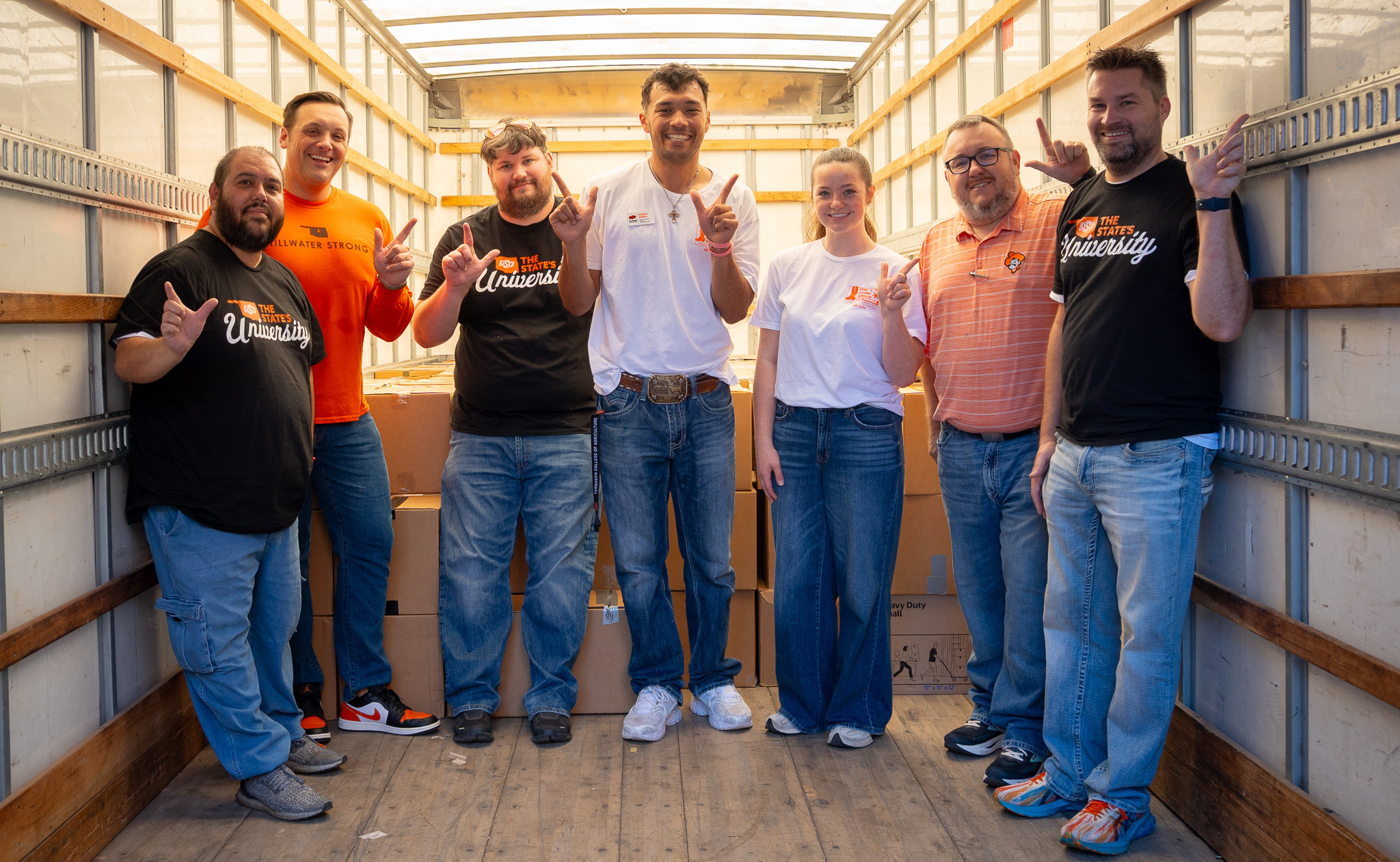 Volunteers stand with boxes of donations from the food drive.