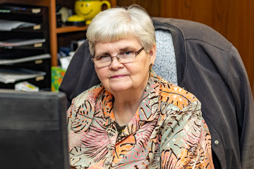 A woman is seated at a desk.