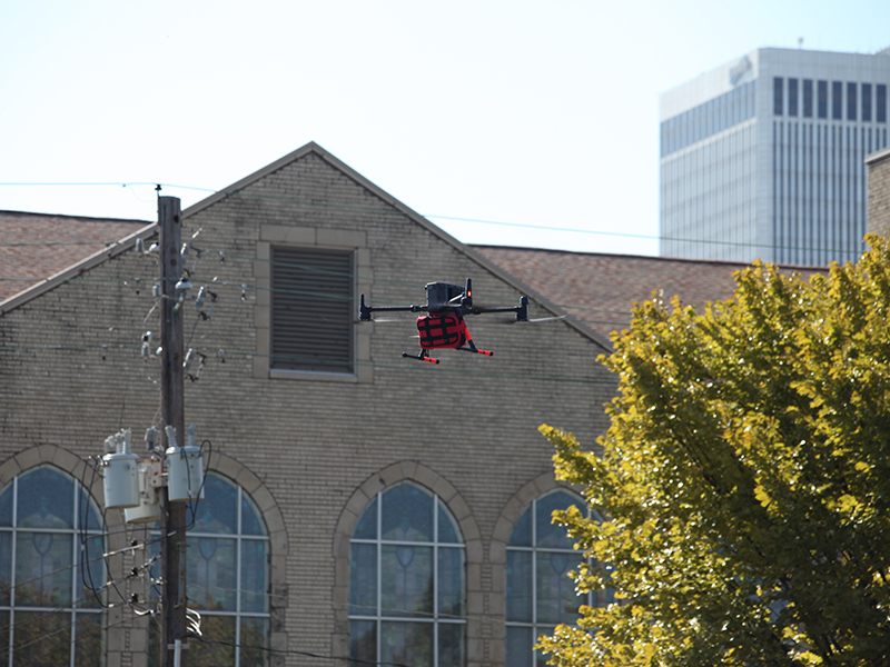 A drone flies in medical supplies as part of a demonstration outside the Helmerich Research Center.