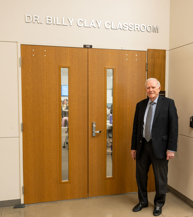 Dr. Clay standing in front of his classroom