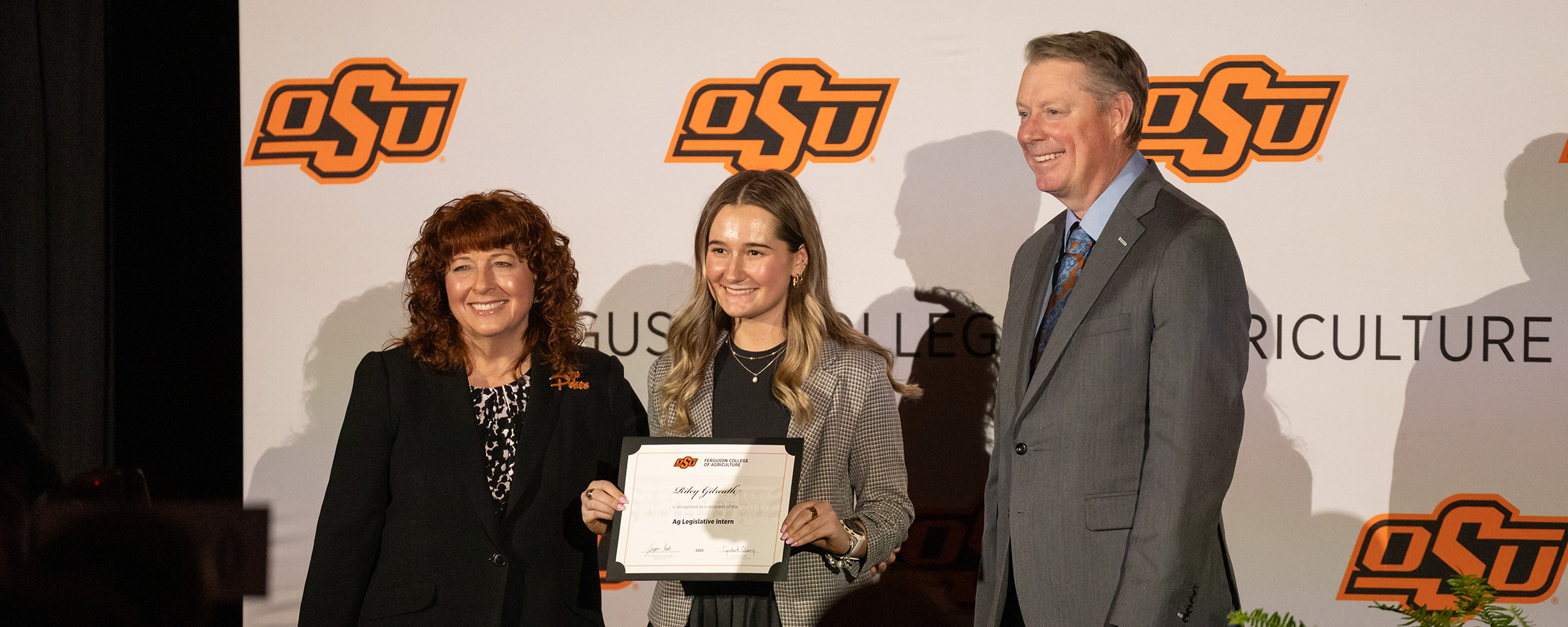Dr's Cynda Clary and Jayson Lusk, associate dean and dean of the Ferguson College of Agriculture, present a student with a scholarship.