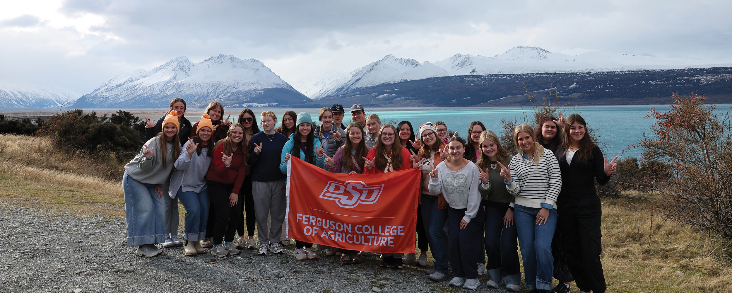 Students pose in front of a mountainous landscape while in New Zealand.