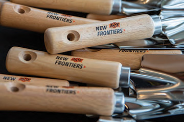 Garden shovels branded with the New Frontiers logo signify the groundbreaking of the New Frontiers Agricultural Hall.