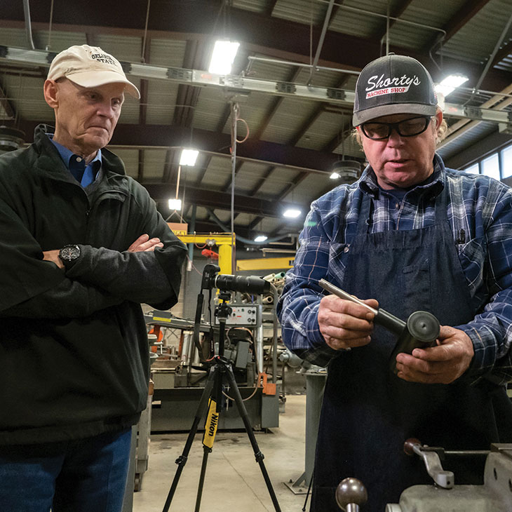 Bill Raun (left) and Nick “Shorty” Sempter evaluate parts for the GreenSeeder.