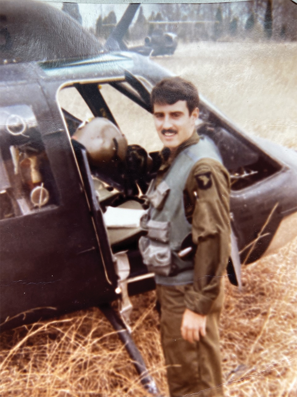 Marc Tower poses in front of his Army helicopter during his days in the service