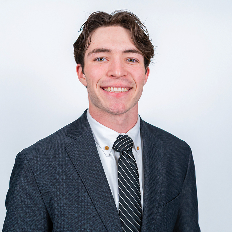 Commodity Cowboys student Parker Lockhart posing for a headshot while wearing a suit and tie.
