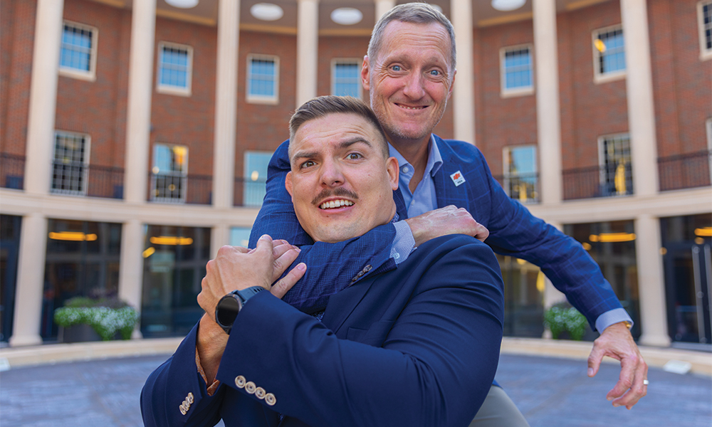 Spears Business MBA director Dr. Matt Bowler playfully puts NCAA champion wrestler Wyatt Hendrickson in a headlock in the Business Building courtyard.