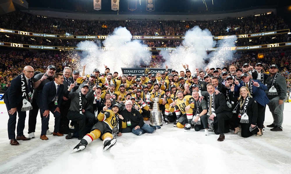 The Vegas Golden Knights team and executives pose on the ice with the Stanley Cup.