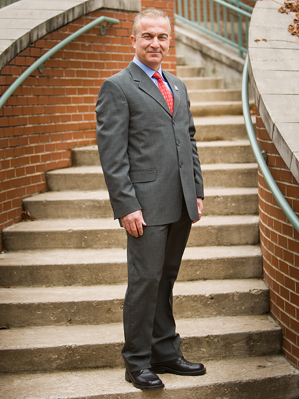 Dr. Dursun Delen poses for an outdoor portrait.