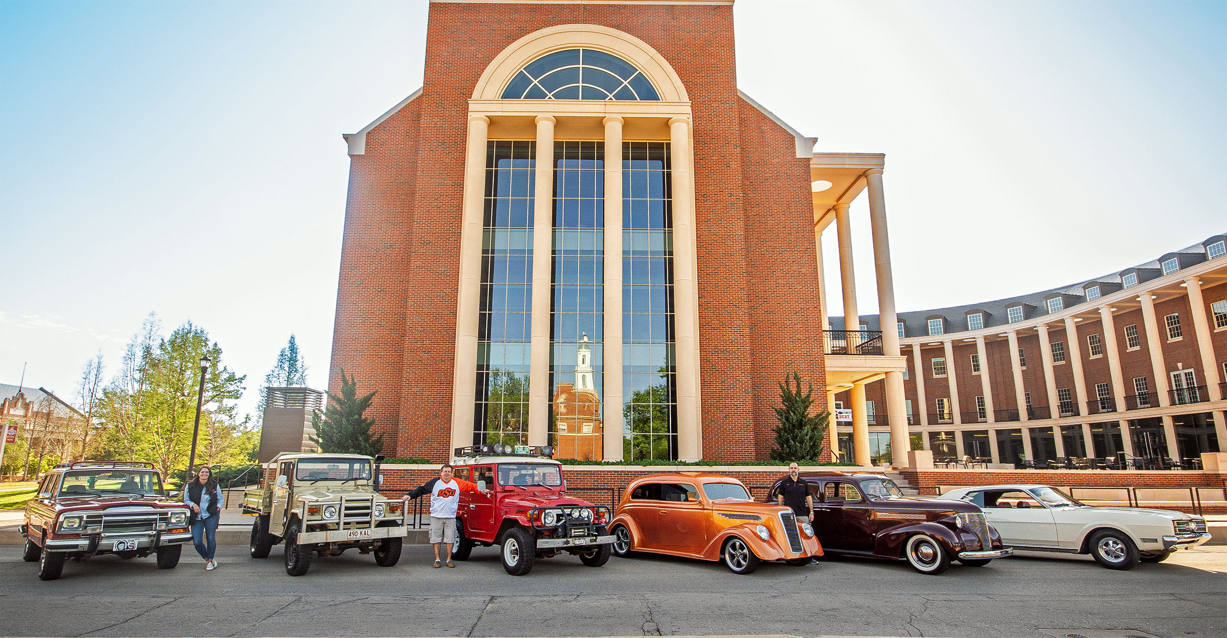 Three Spears Business professors show off their classic cars in front of the Business Building at Oklahoma State University.