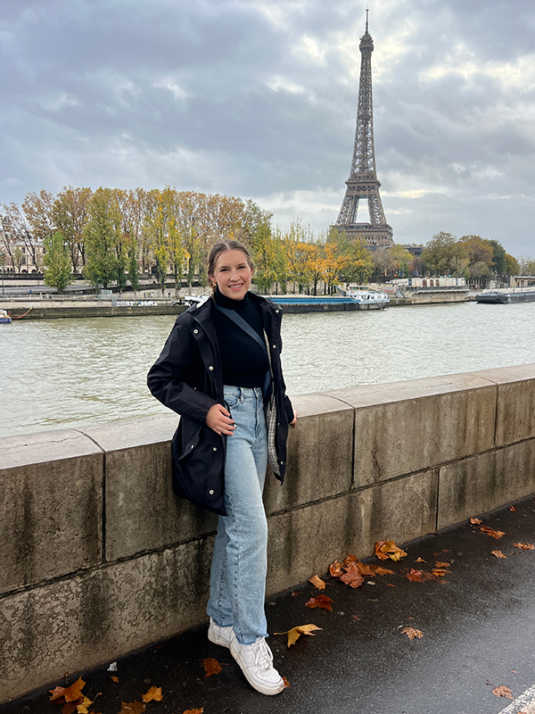 Kylie Austin posing in front of the Eiffel Tower in Paris.