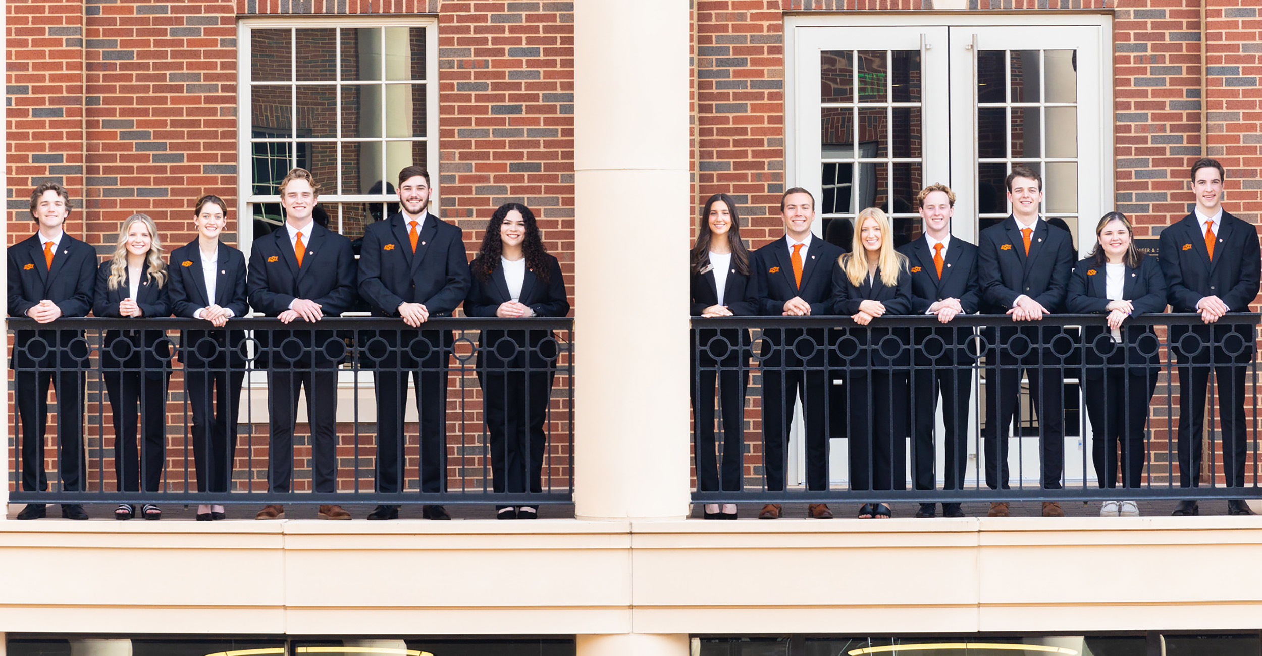 The members of the OSU Competitive sales pose in business dress on the balcony of the Business Building.