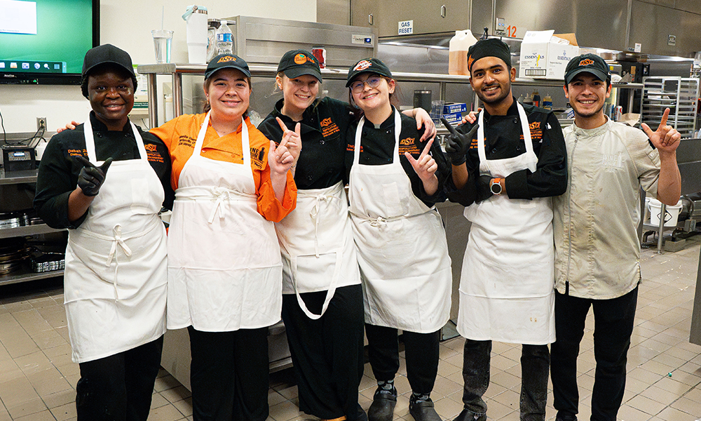 Six OSU students pose in the kitchen during the preparations for the Wine Forum.