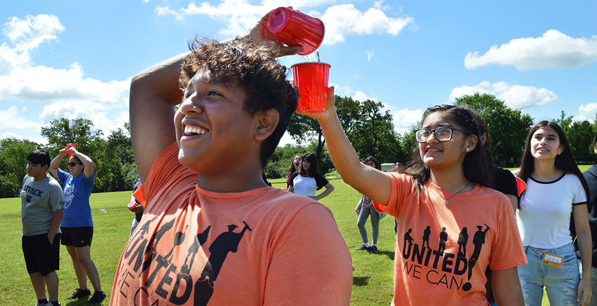 Jonathan Avendano (from left), Gabriella Lopez and Daisy Gallegos pass water between them while playing a game at Camp Okiwanee.