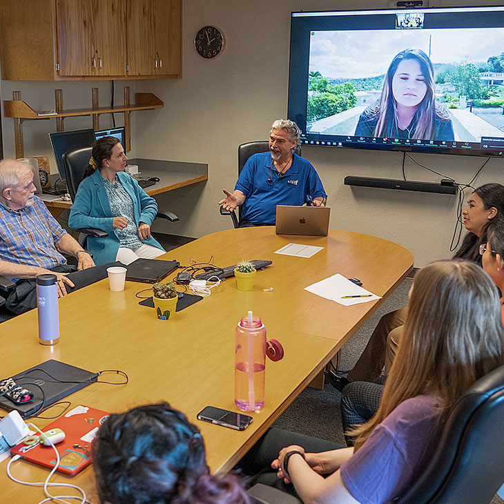 Group sits around conference table at Center for Immigrant Health and Education