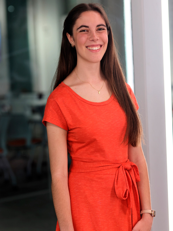 Student smiling in orange dress