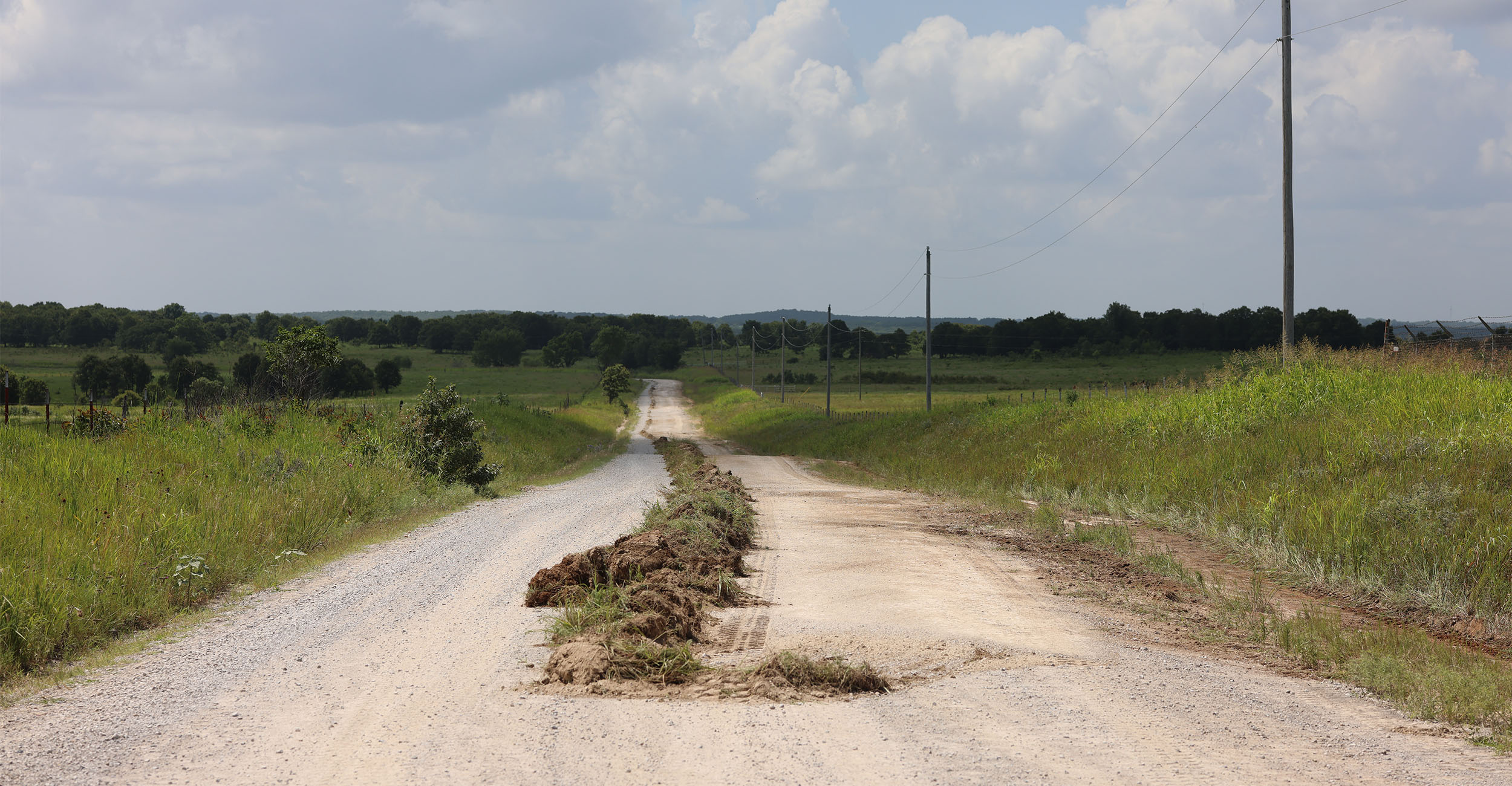 Shown is grass on a rural roadway that was removed from the side ditches by a motor grader. The grass was then cleared by an additional vehicle.