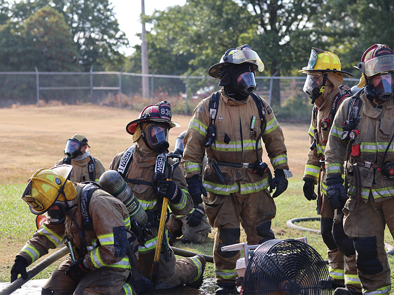 Firefighter trainees with the OSU Fire Safety Program rest in between training excercises on the OSU Fire Safety Training grounds.