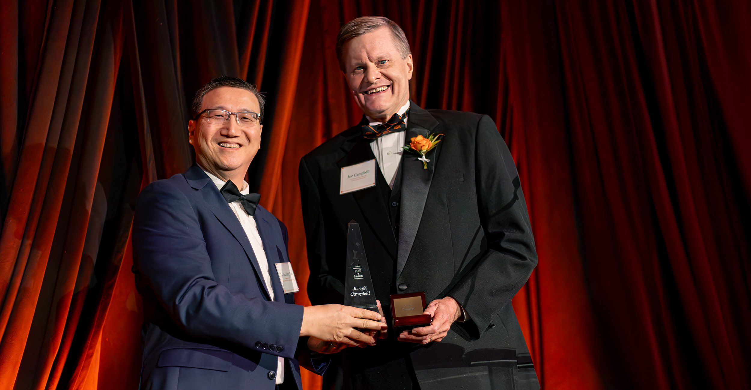 Dr. Joseph Campbell (right) receives two awards from Dr. Guoliang Fan during the 2024 College of Engineering, Architecture and Technology Hall of Fame and Lohmann Medal Award Banquet.