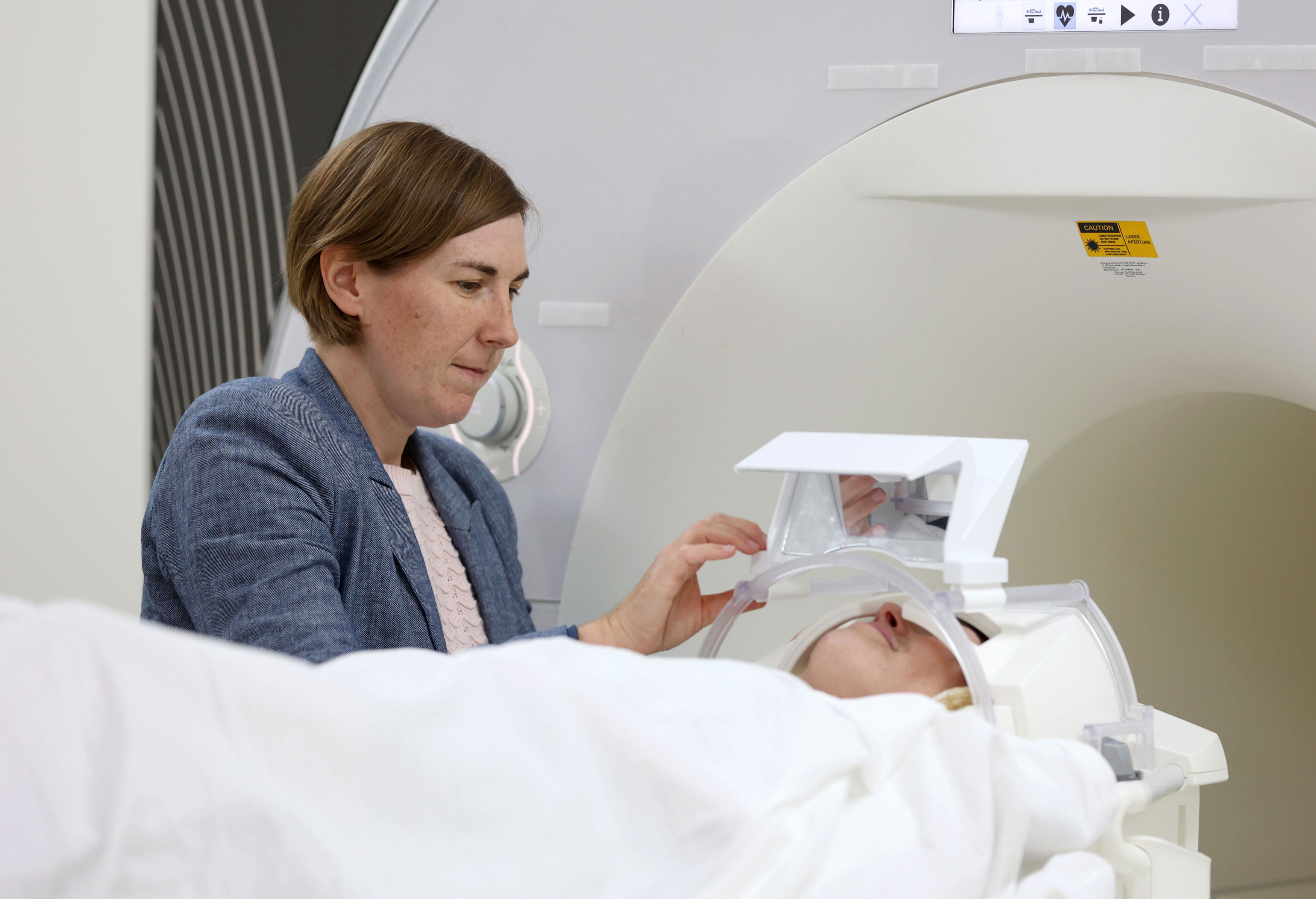  Dr. Kara Kerr, associate professor of psychology, prepares a research study participant for an MRI scan at the Hardesty Center for Clinical Research and Neuroscience in Tulsa.