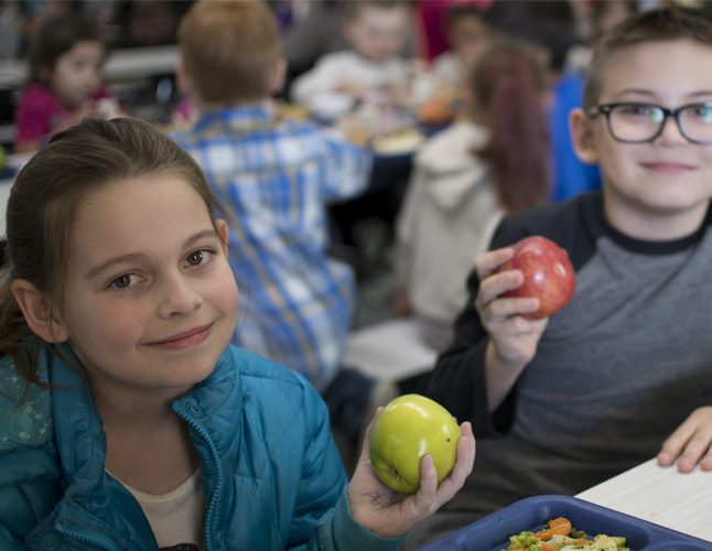 Kids enjoying apples at lunch