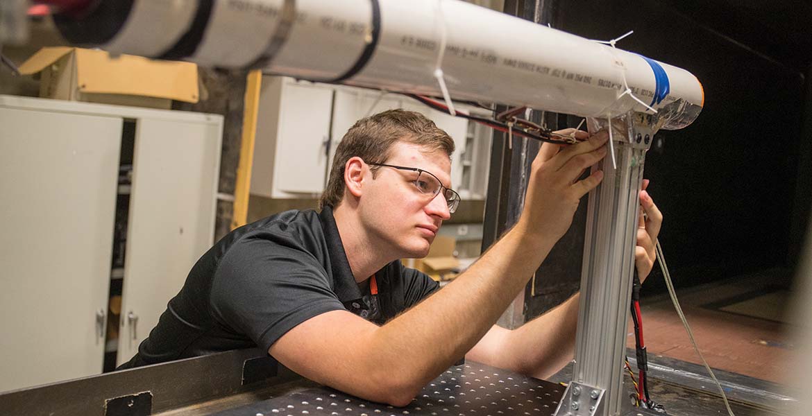 An OSU student working on a piece of aerospace equipment.