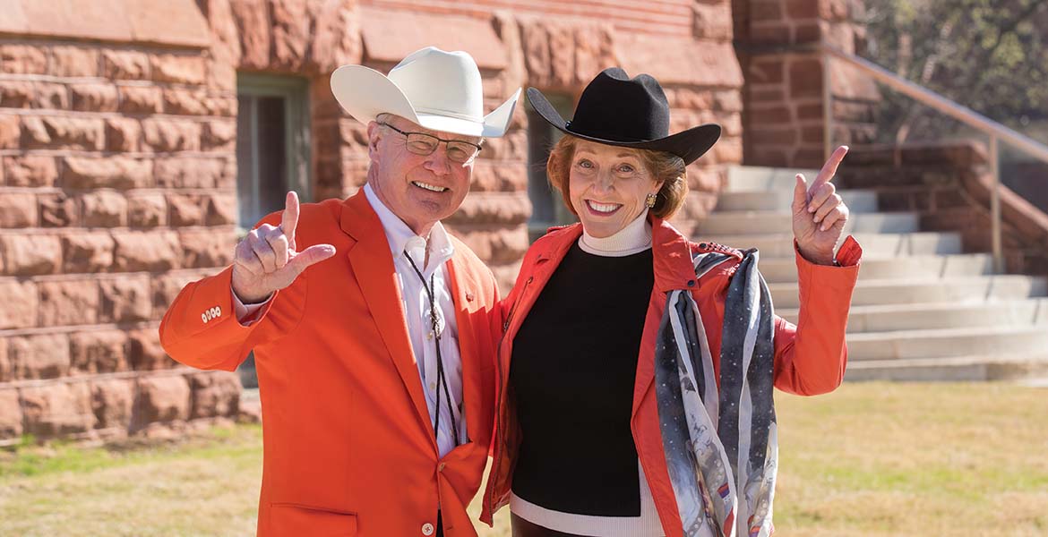 Burns and Ann Hargis holding up the Go Pokes sign