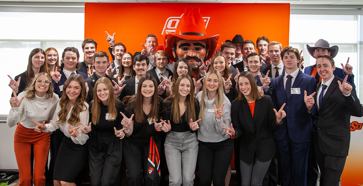 OSU Aviation students pose for a photo with Pistol Pete at the grand opening of the Ray and Linda Booker OSU Flight Center.