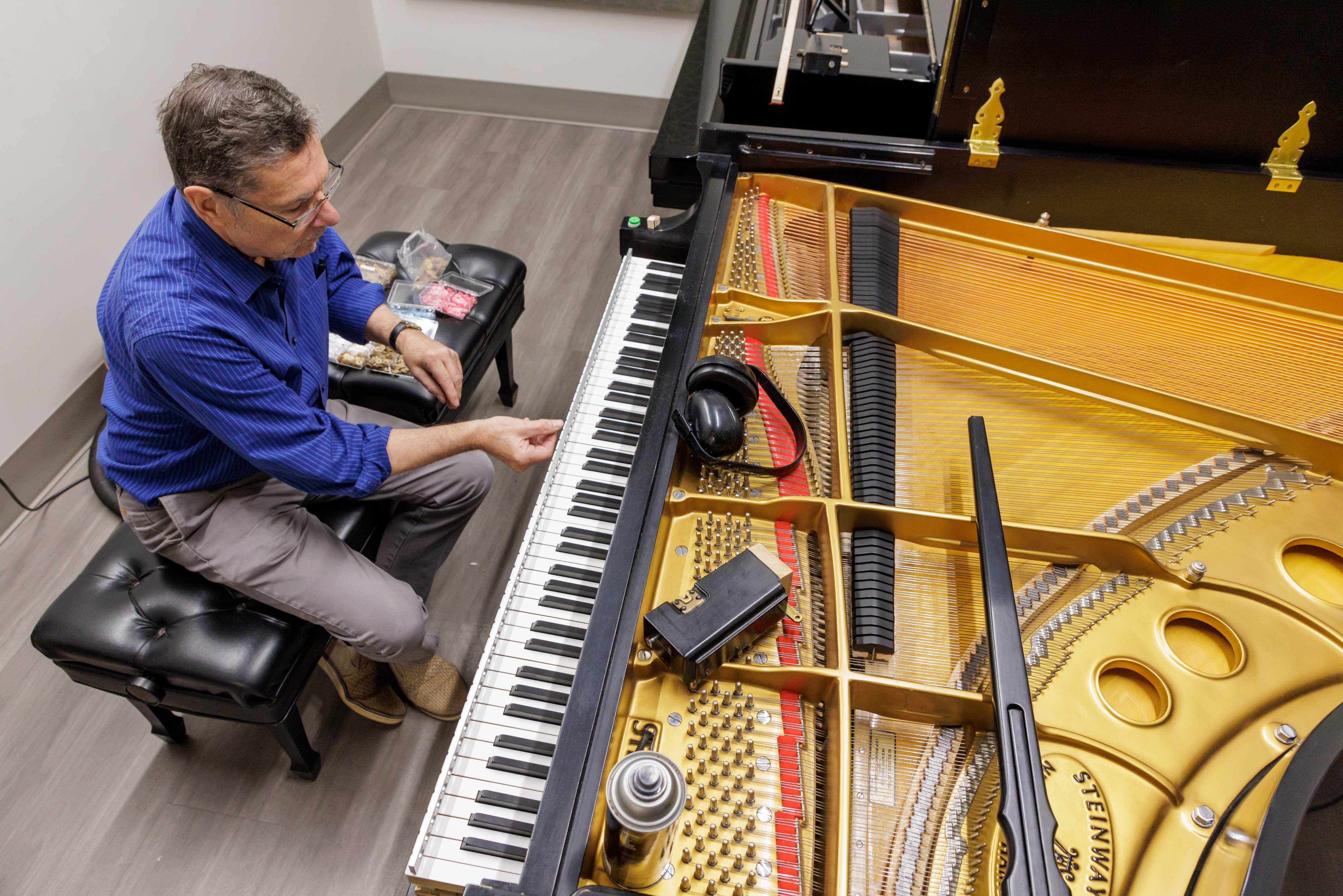 Mrykalo works to tune a piano in one of the practice rooms within the Greenwood School of Music.