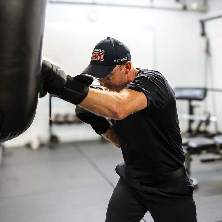 a firefighter performs a boxing workout