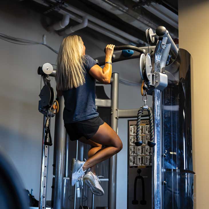 a female police officer wearing workout clothes performs pull-ups