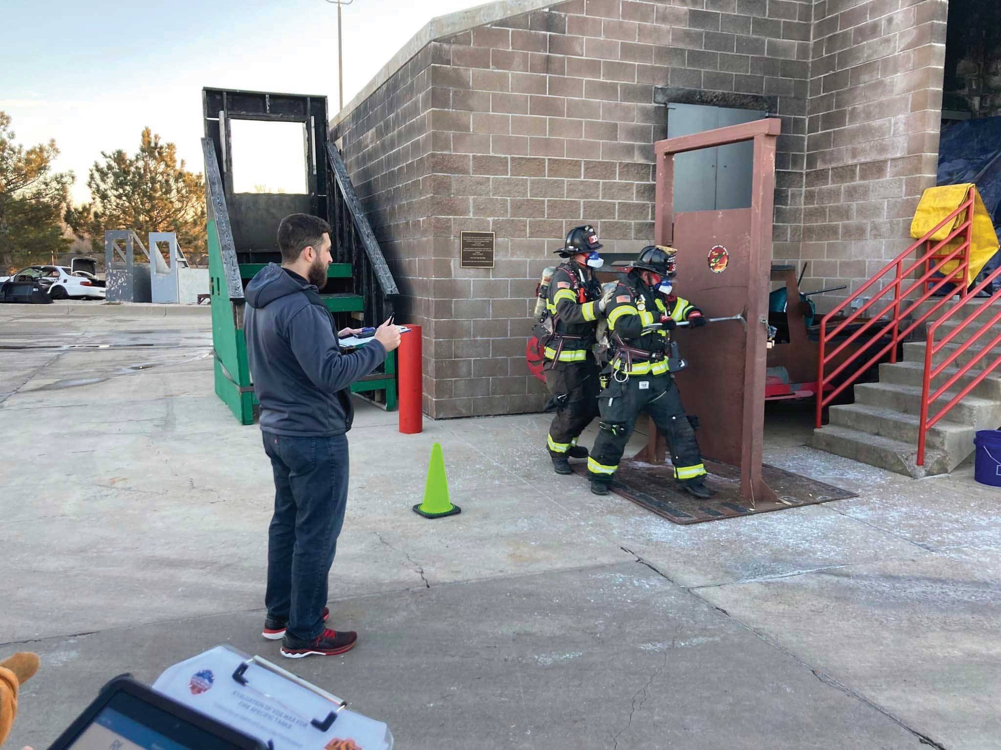 firefighters practice opening a door with tools