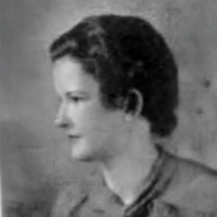 A grayscale photograph of a woman with short, wavy hair. She is wearing a collared shirt and is positioned against a plain background."