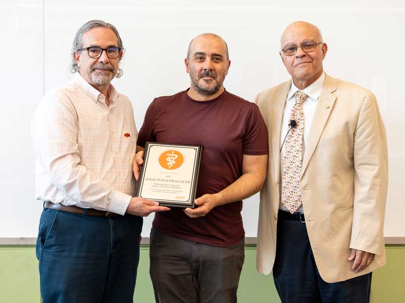 Dr. João Brandão receives the 2024 Zoetis Veterinary Research Excellence Award from Dr. Jerry Malayer, senior associate dean and Dean Dr. Carlos Risco.