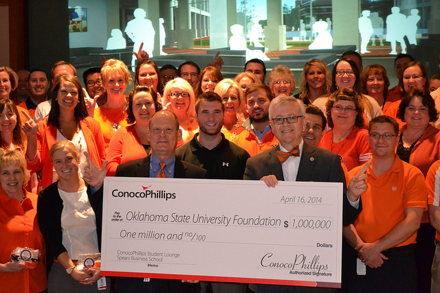 ConocoPhillips announced a $1 million donation toward building a new home for Oklahoma State University’s Spears School of Business. During an event in Bartlesville, Okla., Ken Seaman (pictured left holding check), ConocoPhillips’ executive sponsor for OSU and a university alum, presented a check for $1 million to OSU’s Dr. Ken Eastman (pictured right holding check), interim dean and associate professor of management, Spears School of Business. They are joined by some of the 440 ConocoPhillips employees who are OSU alumni.