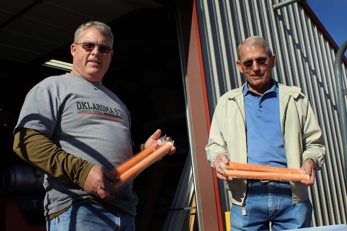 Terry Fagan, Hydro Foam sales director and Dennis Fagan, Hydro Foam president, are holding a water soluble product that’s formulated to improve oil bit performance. The orange polymer stick is an effective drill bit cleaner, solids dispersant and drilling fluid thinner.