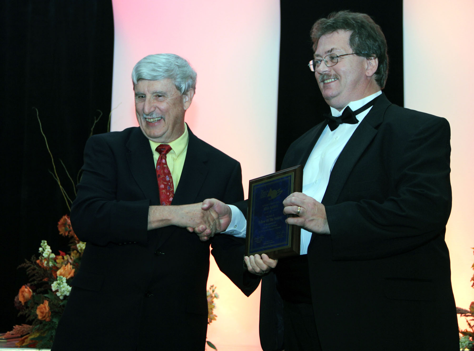 George Wicks, president of the American Ceramic Society, awards a plaque to Dr. Allen Apblett formally recognizing Apblett as a Fellow in the society.