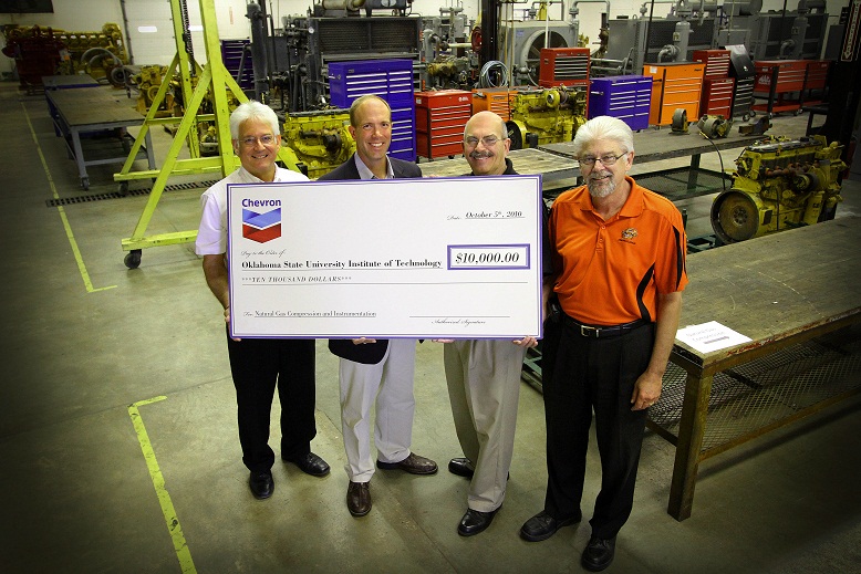 Holding the Chevron donation check are, left to right: Roy Achemire, HEVi Technologies program chair; Dwight Alworth from Chevron; Mike Taylor, Engineering Technologies division chair; and Steve Doede, Automotive Technologies division chair.
